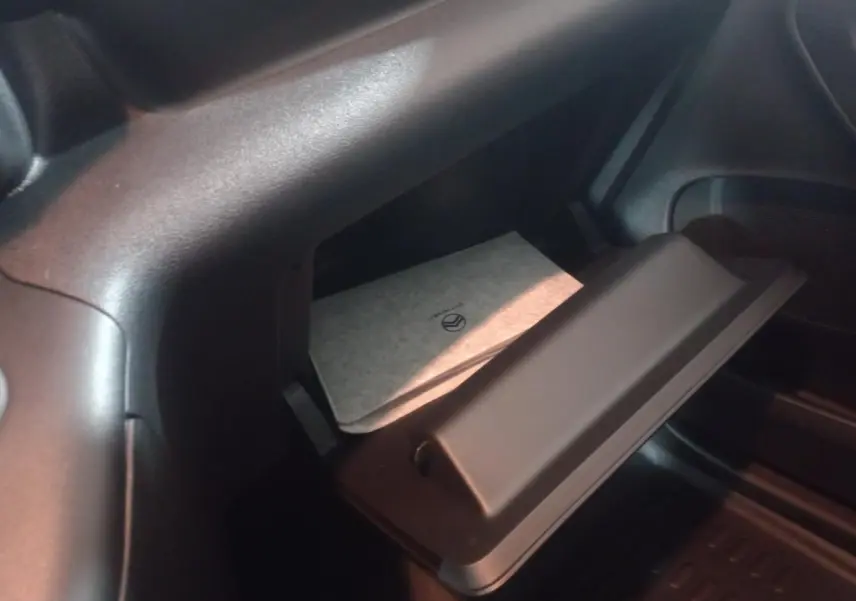 Vue intérieure sur la boîte à gants ouverte du Citroën Berlingo XL blanc 2025 avec rangement réfrigéré visible.