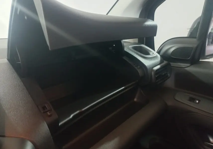 Vue intérieure côté passager du coffre à gants ouvert du Citroën Berlingo XL blanc, avec aérateur et rétroviseur visible.