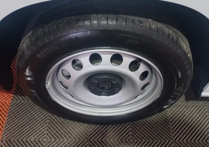 Gros plan sur la roue avant droite du Citroën Berlingo blanc, jante acier avec logo Citroën au centre.