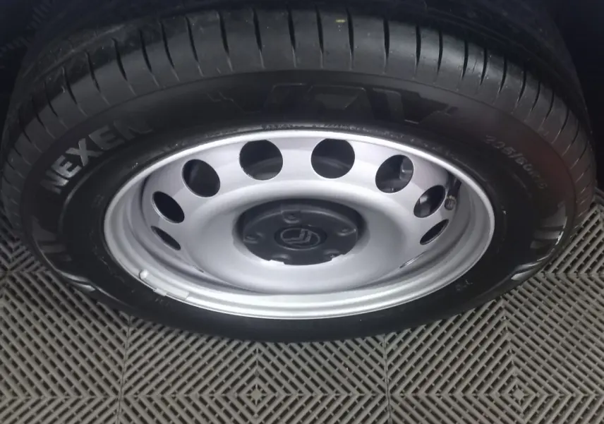 Gros plan sur la roue avant avec jante acier argentée et pneu Nexen du Citroën Berlingo blanc 2025.