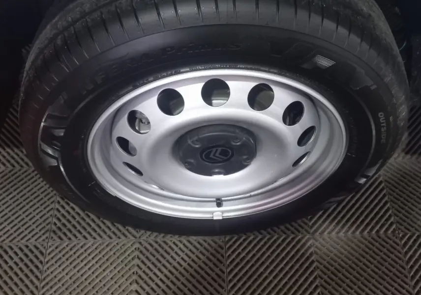 Gros plan sur la roue acier avec jante argentée et logo Citroën au centre du Berlingo blanc 2025.