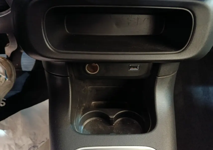 Vue rapprochée de la console centrale noire avec prises USB et allume-cigare dans une Citroën C3 blanche 2021.