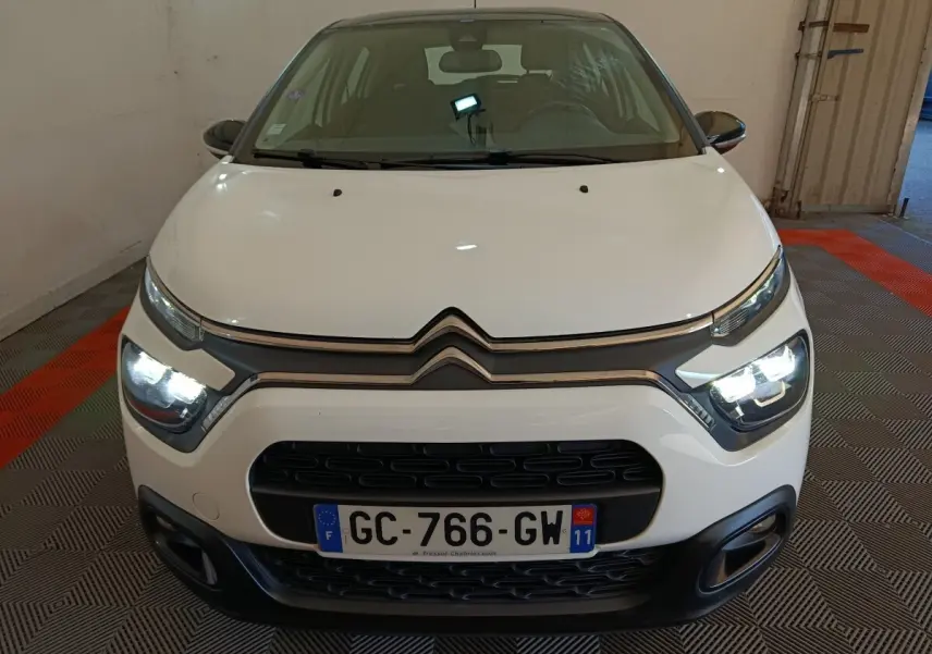 Vue avant d'une Citroën C3 blanche 2021 avec phares LED allumés et calandre noire distinctive.