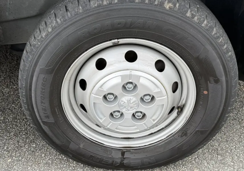 Gros plan sur la roue avant gauche du Peugeot Boxer Fourgon blanc, mettant en valeur la jante acier et le pneu Nexen Roadian.