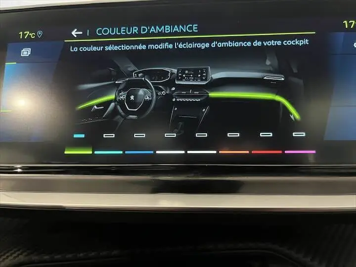Écran tactile intérieur de la Peugeot e-208 GT 2022 montrant la sélection de la couleur d'ambiance avec un éclairage vert.