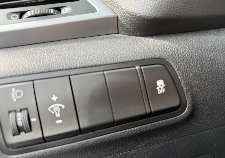 Gros plan sur les commandes de réglage d'éclairage et de stabilité du tableau de bord noir du Hyundai Tucson gris 2015.