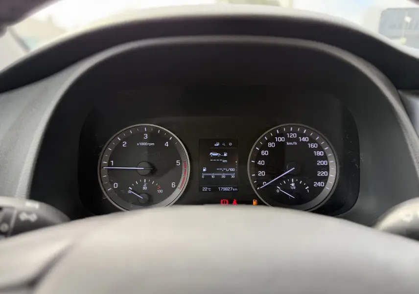 Tableau de bord du Hyundai Tucson gris 2015, affichant compte-tours, vitesse, température et écran central numérique.