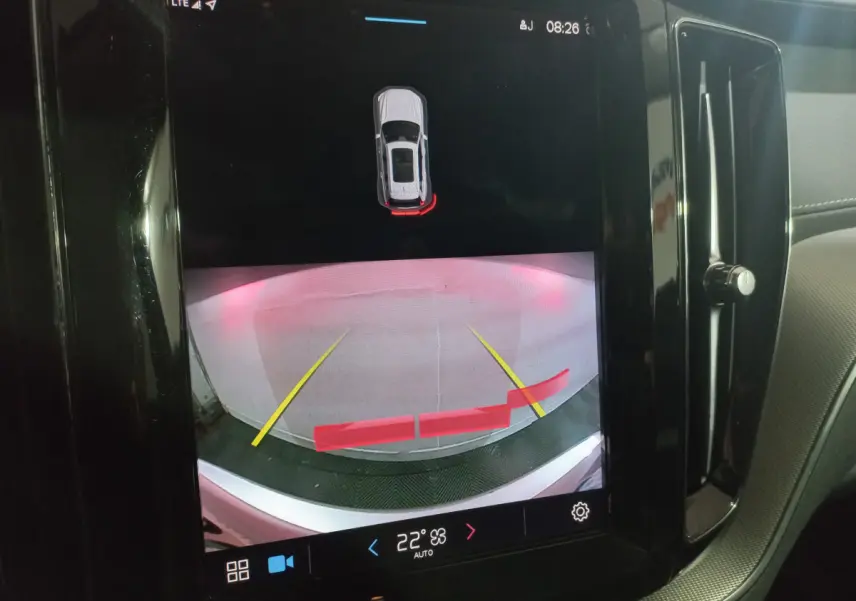 Écran tactile intérieur montrant la caméra de recul avec guidage et alertes du Volvo XC60 gris clair B4 2022.