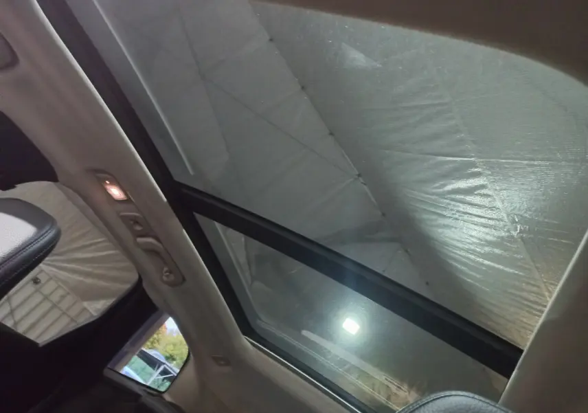 Toit panoramique en verre du Volvo XC60 B4 gris clair vu de l'intérieur côté arrière droit