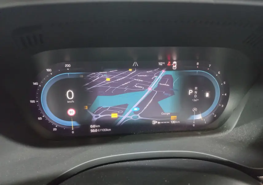 Affichage numérique du tableau de bord du Volvo XC60 gris clair, avec navigation et indicateurs de vitesse et mode.