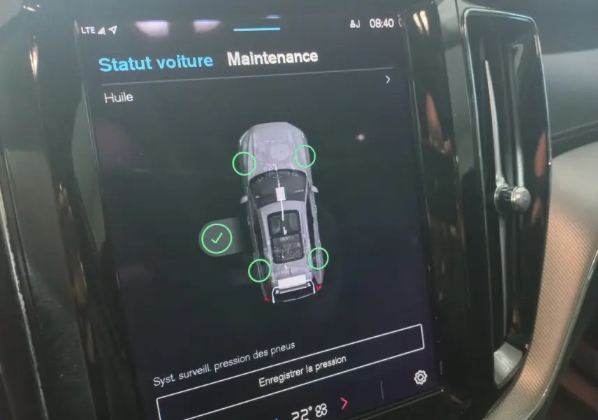 Écran tactile intérieur du Volvo XC60 B4 gris clair affichant le statut maintenance et pression pneus.