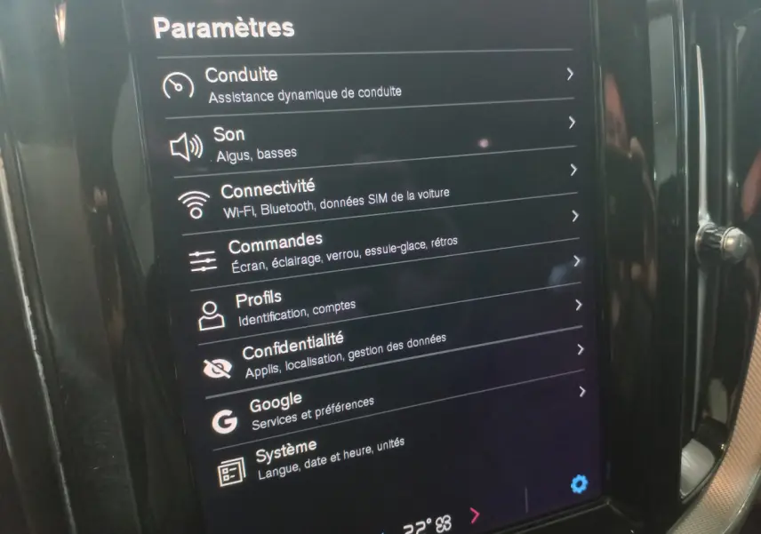 Écran tactile central affichant les paramètres du système multimédia dans un Volvo XC60 gris clair, vue intérieure rapprochée.