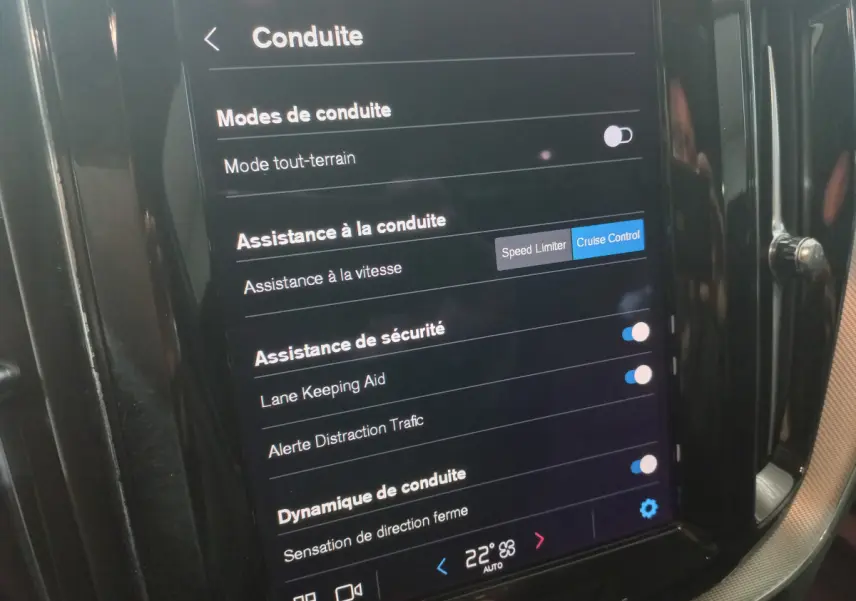 Écran tactile central du Volvo XC60 B4 gris clair montrant les réglages d'assistance à la conduite et sécurité