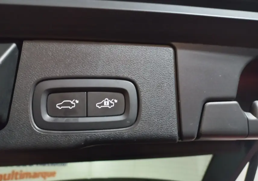 Gros plan sur les boutons d'ouverture et de verrouillage électrique du coffre du Volvo XC60 gris clair, version Inscription.