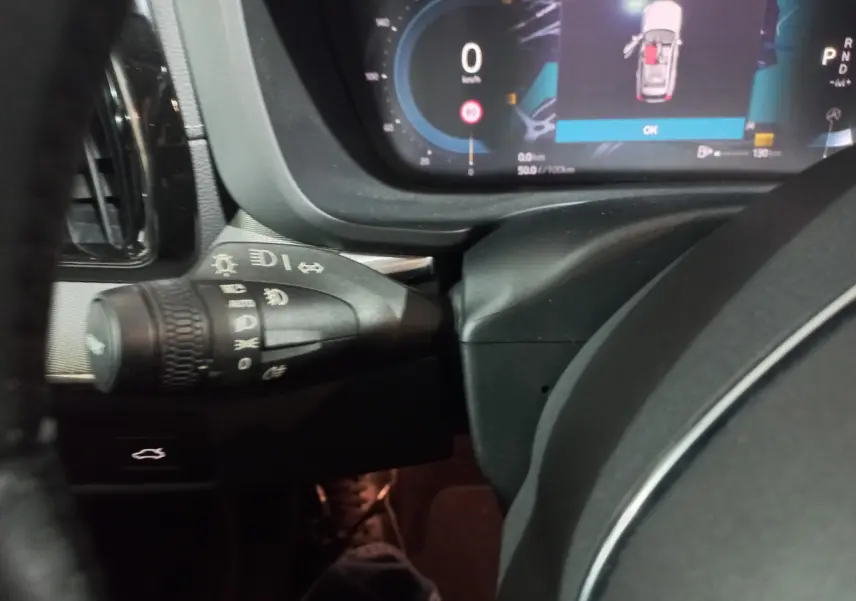 Gros plan sur la commande des phares et le tableau de bord digital du Volvo XC60 B4 gris clair, version 2022.