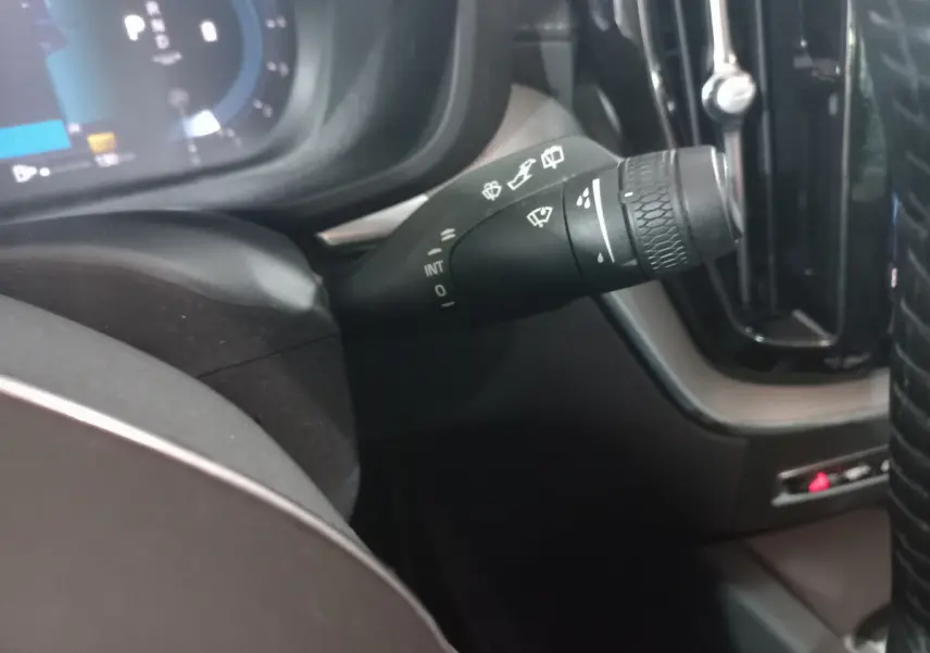 Gros plan sur la manette d’essuie-glace côté droit du tableau de bord du Volvo XC60 gris clair 2022.