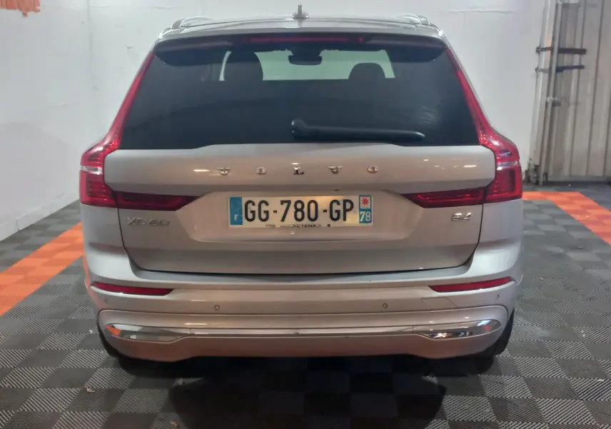 Vue arrière d'un Volvo XC60 gris clair avec feux LED caractéristiques et logo visible sur coffre.