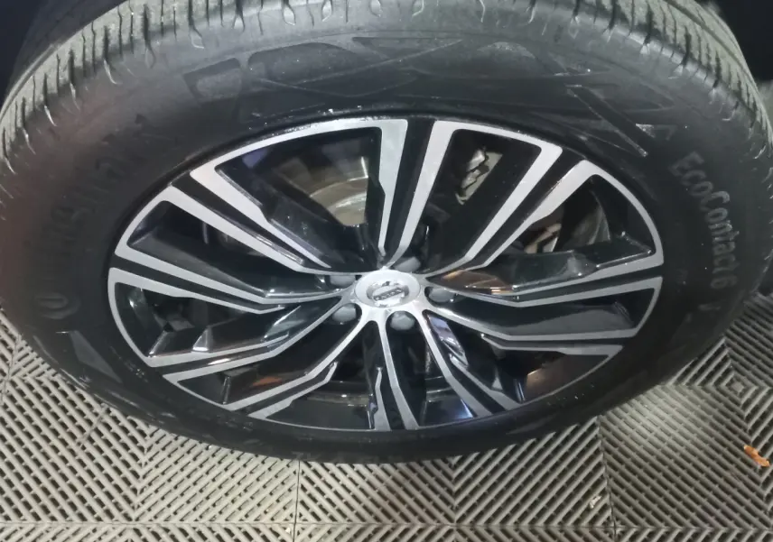 Gros plan sur la jante noire et argentée du Volvo XC60 B4 2022, avec pneu Continental EcoContact 6 visible.