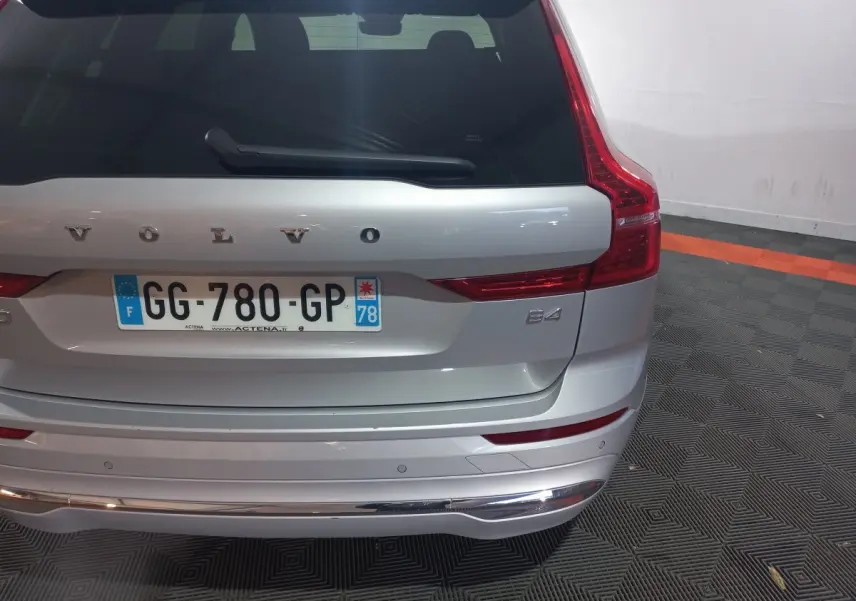 Vue arrière d'un Volvo XC60 B4 gris clair avec feux LED verticaux et plaque d'immatriculation française visible.