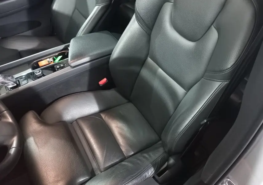 Gros plan sur siège conducteur en cuir noir et console centrale du Volvo XC60 B4 gris clair, version Inscription 2022.