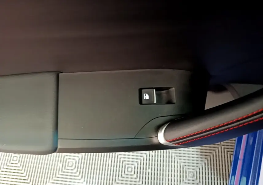Détail de la commande de verrouillage sur la porte côté conducteur d’une SEAT Leon bleu 1.5 eTSI 150 DSG S&S FR 2021.