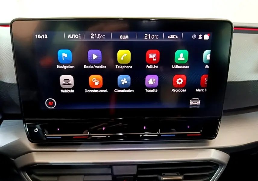 Écran tactile central du tableau de bord de la SEAT Leon 1.5 eTSI 150 DSG S&S FR avec interface colorée et commandes climatisation.