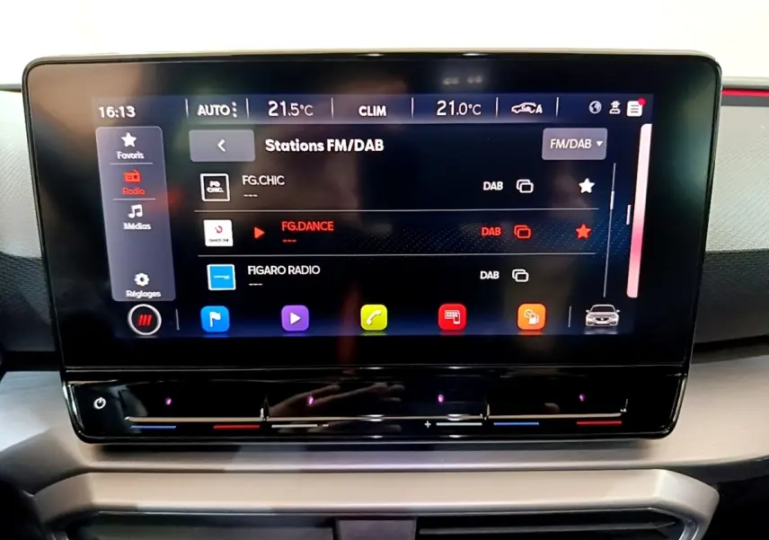 Écran tactile central du tableau de bord du SEAT Leon 1.5 eTSI bleu, affichant les stations radio FM/DAB.