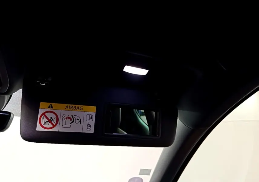 Détail intérieur du pare-soleil côté conducteur avec miroir et éclairage dans une SEAT Leon bleu 2021.