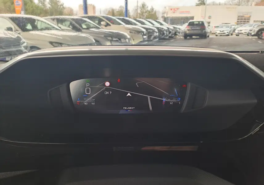 Tableau de bord numérique de Peugeot 308 gris Artense 2023 affichant la navigation et l'état du véhicule en vue frontale.