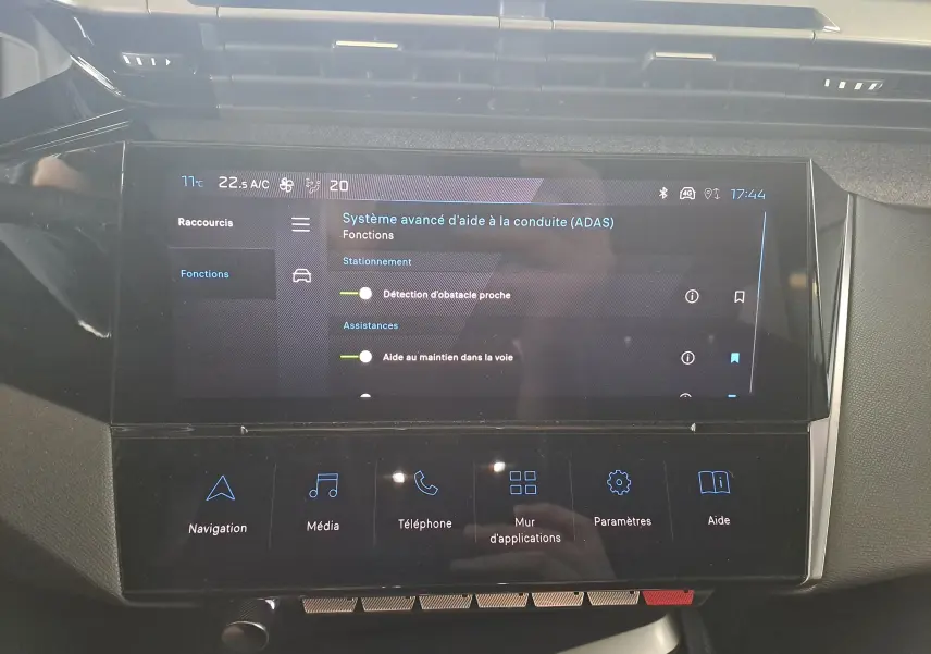 Écran tactile central du tableau de bord de la Peugeot 308 gris Artense 2023 affichant les aides à la conduite avancées.