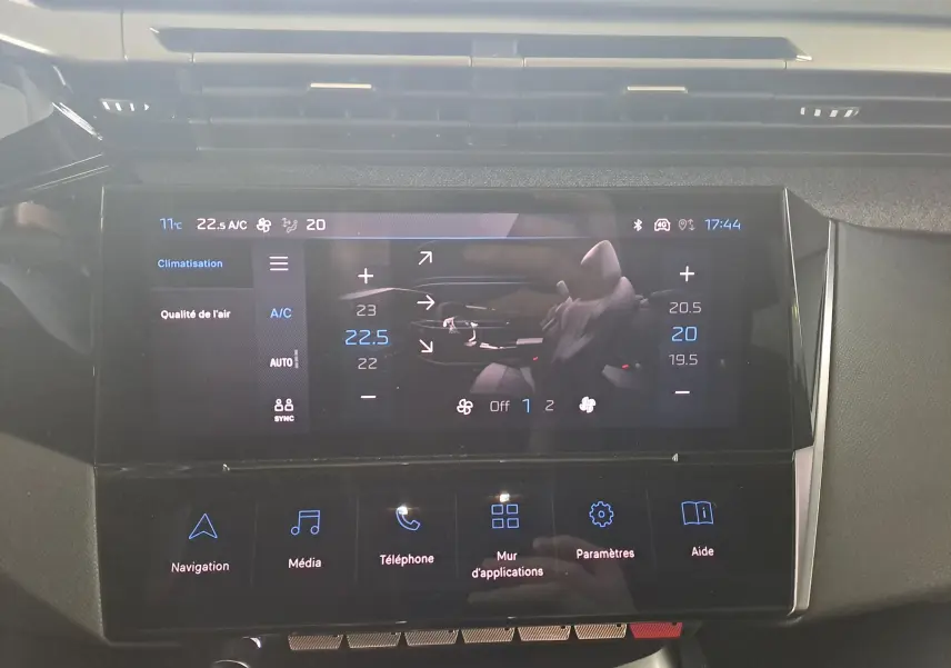 Écran tactile central de la Peugeot 308 2023 gris Artense, affichant la climatisation et les options multimédias.