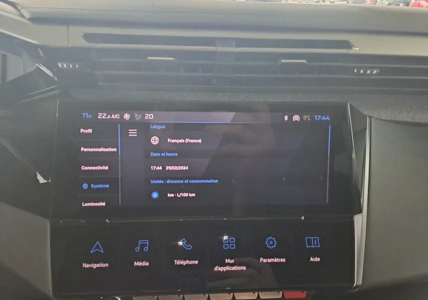Écran tactile central de la Peugeot 308 gris Artense 2023, affichant les réglages système et options multimédia.