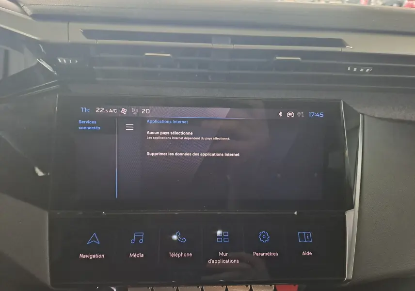 Écran tactile central du tableau de bord de la Peugeot 308 gris Artense, affichant les applications internet et options multimédia.