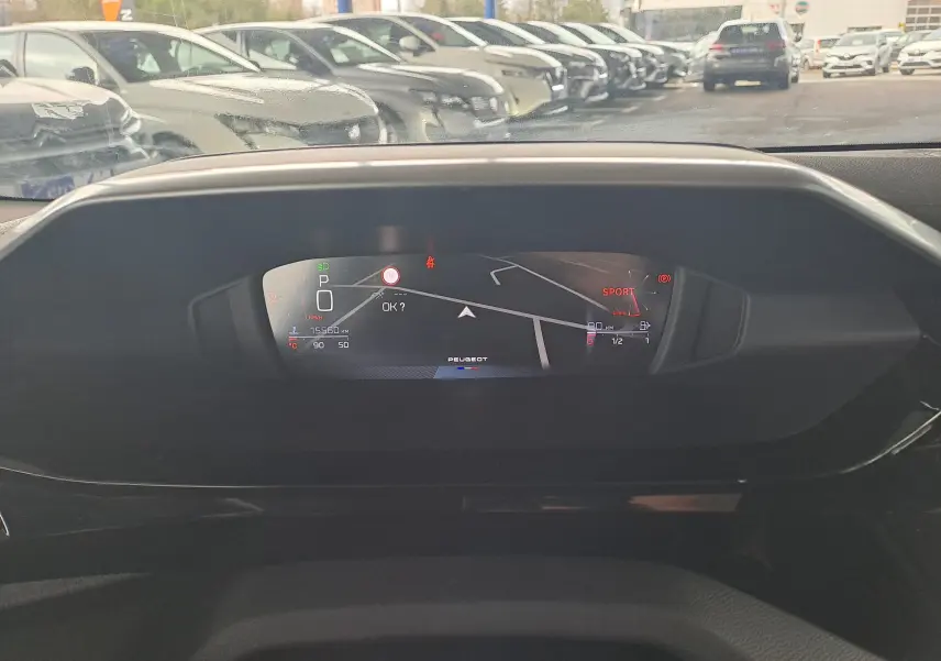 Affichage numérique du tableau de bord de la Peugeot 308 gris Artense 2023, avec navigation et mode sport visible.