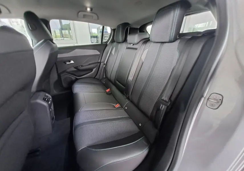 Vue intérieure côté droit des sièges arrière en tissu gris avec surpiqûres bleues d'une Peugeot 308 2023 gris Artense.