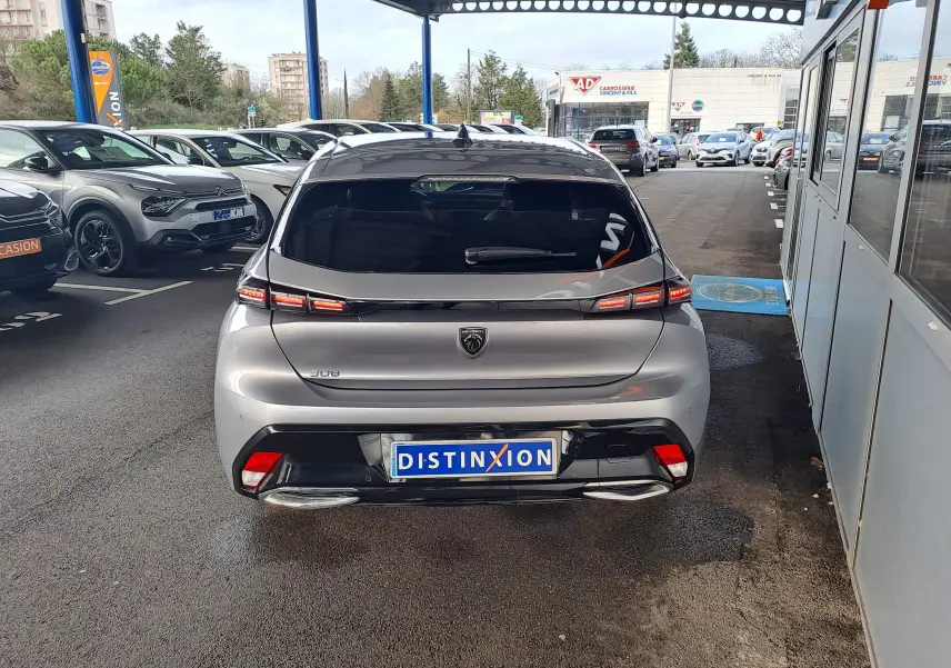 Vue arrière d'une Peugeot 308 gris Artense 2023 avec feux LED distinctifs et double sortie d'échappement chromée.