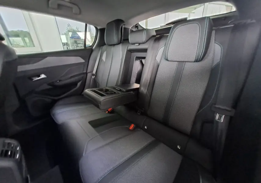 Vue intérieure arrière côté gauche des sièges gris foncé avec accoudoir central déplié de la Peugeot 308 2023