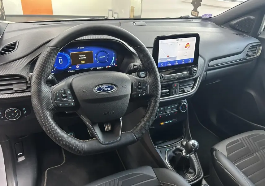 Intérieur du Ford Puma 2023 gris, vue du poste de conduite avec volant multifonction et écran tactile central.