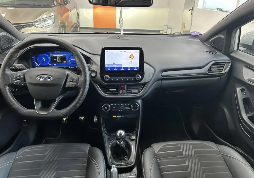 Intérieur du Ford Puma 2023, vue frontale du tableau de bord et volant avec écran tactile central allumé.