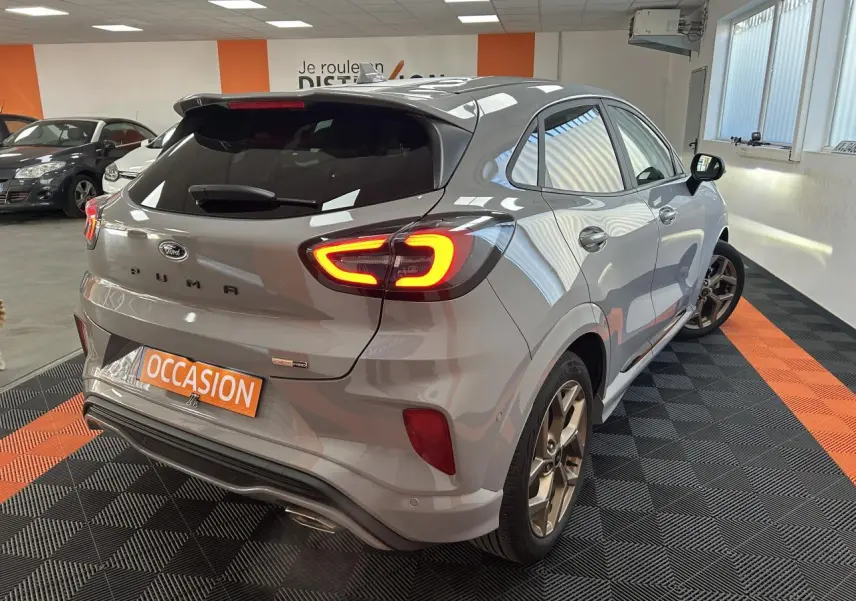 Vue 3/4 arrière droite d'une Ford Puma gris métallisé avec feux arrière LED et jantes alliage 18 pouces finition Gold.