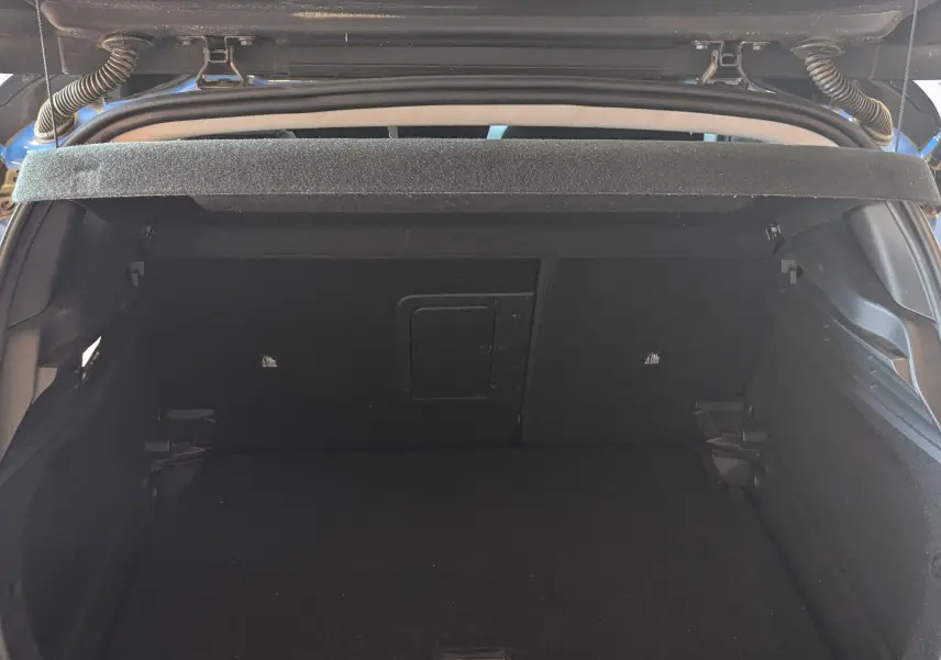 Coffre ouvert vu de l'arrière d'une Opel Astra 1.5D bleu 2022, montrant l'espace de chargement vide et la plage arrière.