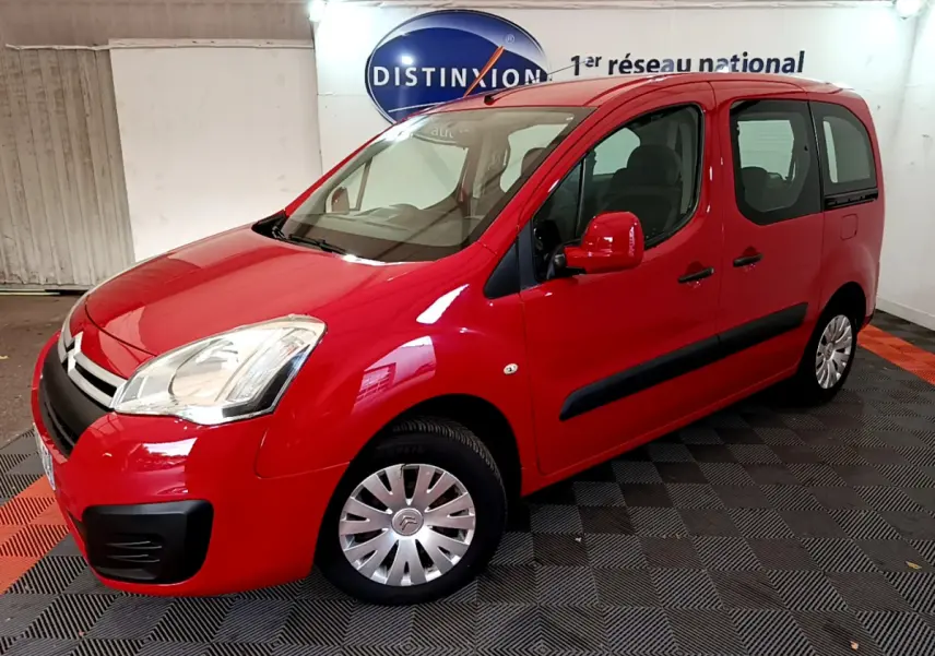 Citroën Berlingo BlueHDi 75 rouge vu en 3/4 avant droit dans un garage avec logo Distinxion en arrière-plan