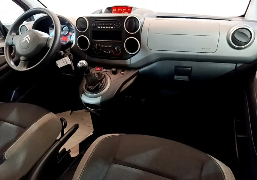 Intérieur du Citroën Berlingo 2016, vue du tableau de bord et volant côté conducteur, sièges noirs.