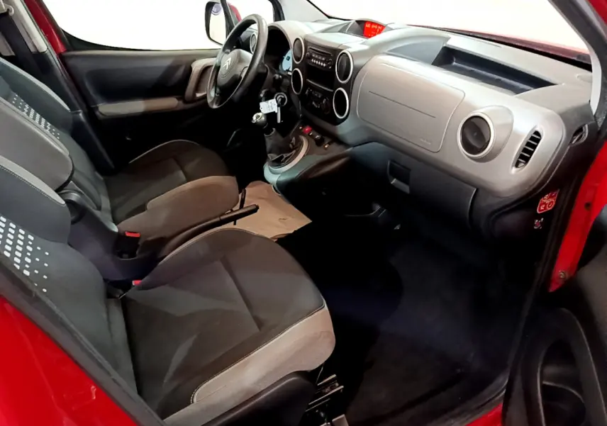 Intérieur du Citroën Berlingo rouge 2016, vue côté conducteur, tableau de bord et sièges avant en tissu gris.