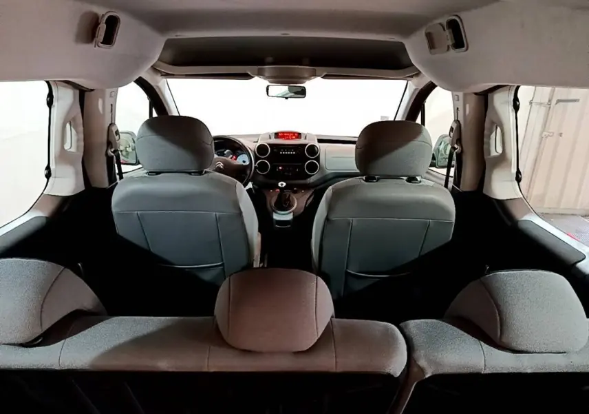 Vue intérieure arrière du Citroën Berlingo BlueHDi 75 BVM Feel 2016, sièges gris et tableau de bord visible.