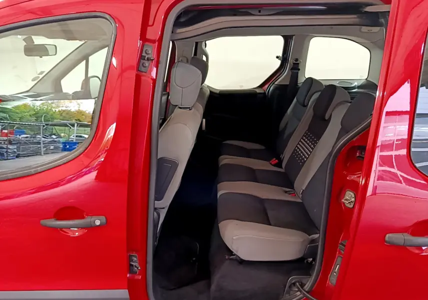 Vue latérale gauche du Citroën Berlingo rouge 2016 avec porte coulissante ouverte sur la banquette arrière trois places.