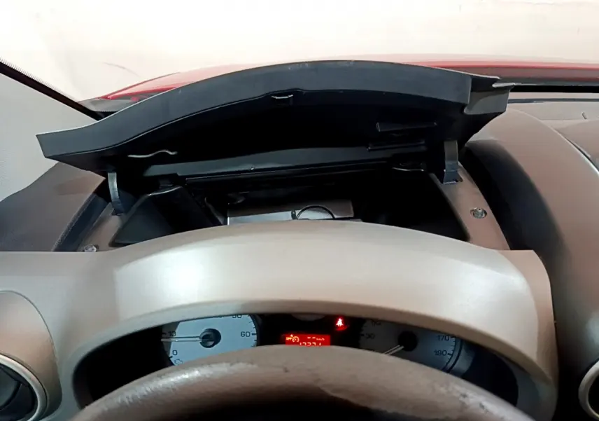 Vue intérieure centrée sur le tableau de bord et le volant beige du Citroën Berlingo rouge de 2016.