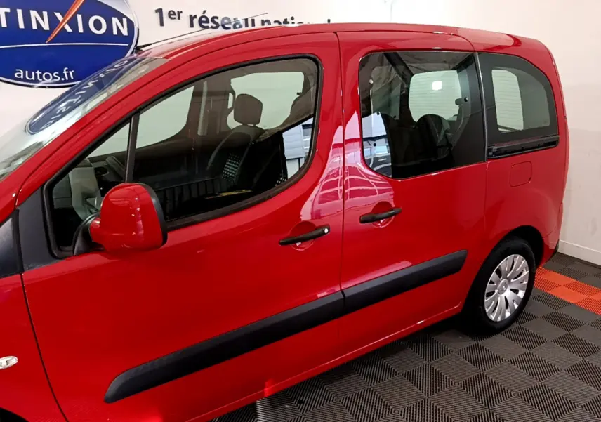 Vue latérale gauche d'un Citroën Berlingo rouge 2016 avec poignées et rétroviseurs assortis, intérieur visible.