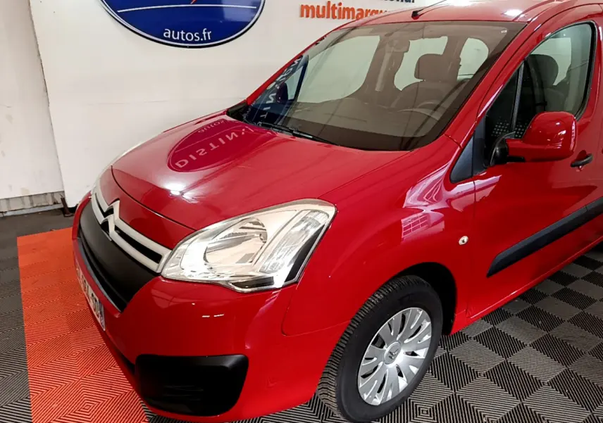 Vue 3/4 avant droit d'un Citroën Berlingo rouge avec phares halogènes et protections latérales noires.