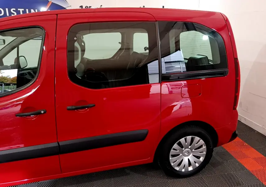 Profil côté gauche du Citroën Berlingo rouge 2016, mettant en valeur ses portes coulissantes et fenêtres arrière larges.